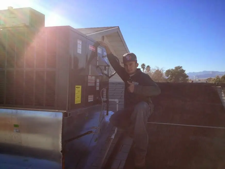 HVAC technician performing Heat Pump Repair on a rooftop unit in Camp Verde